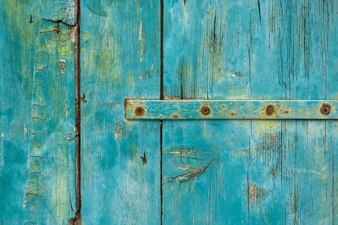 Old wooden door with peeling paint and iron fittings, texture, background, Montenegro, Balkans,