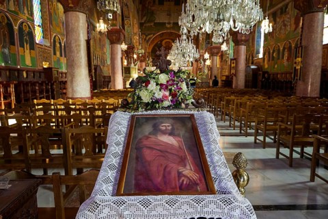 Large church room with a portrait of Jesus and floral decorations on an altar, surrounded by