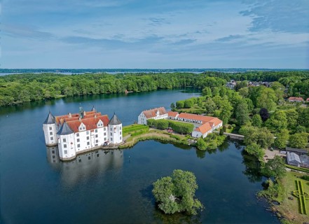 Glücksburg Castle and the castle pond. The lake is part of the Munkbrarupau stream. Aerial view.