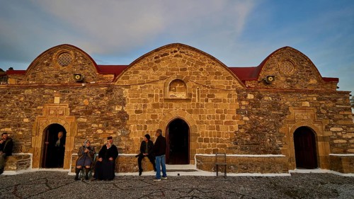 Old stone building in the evening light, people standing in front of the historic facade, Easter
