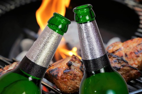 (Photomontage) Two beer bottles in front of grilled meat