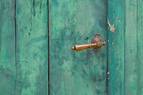 Old green wooden door with peeling paint and metal handle, metal latch, Croatia, Europe