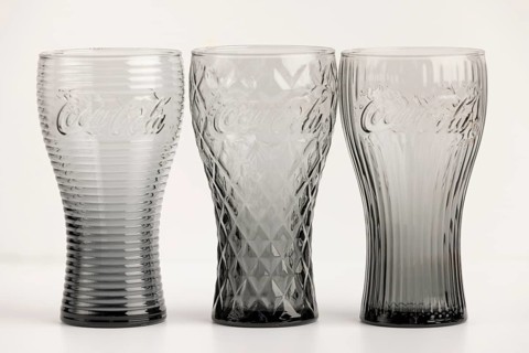 Three stylish, differently designed cola glasses in transparent and black tones