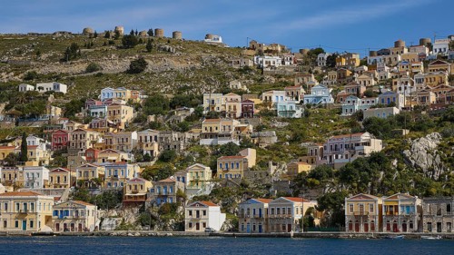 Colourful harbour village on a hill with traditional Greek architecture, Symi Town, Symi,