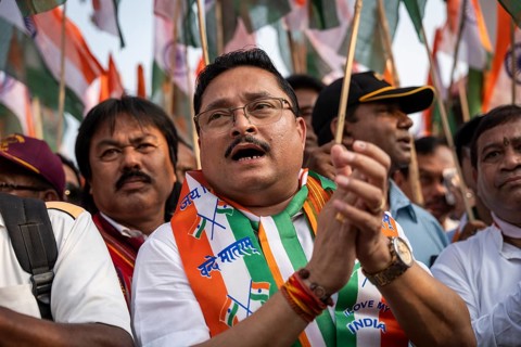 People holding Indian national flags as they take part in a rally, in soliderity with the Indian