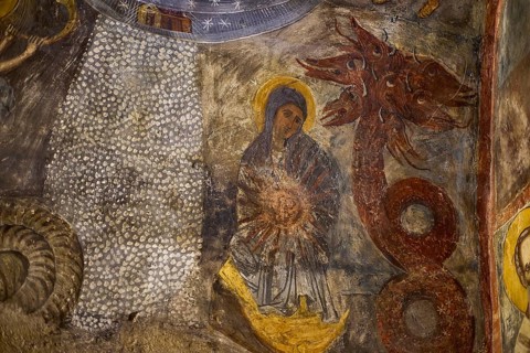 The fresco shows Mary next to a dragon-like creature with intense symbolism in a medieval context,