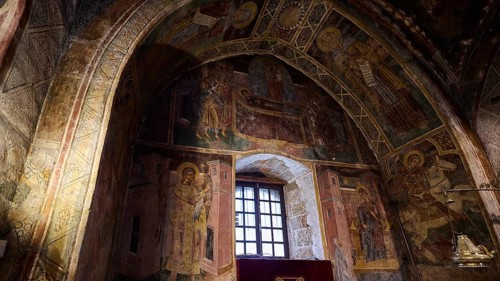 Richly decorated church interior with icons and an altar table covered with purple fabric, Thari