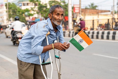 A differently abled person holds a tricolour as he take part in a rally, in soliderity with the