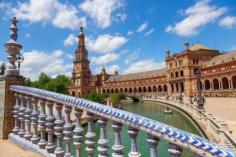 Plaza de España in Seville with magnificent architecture and bridge on a sunny day with clouds,
