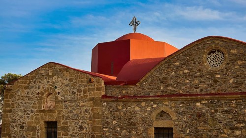 An old church with a red roof and a cross in front of a clear blue sky, Easter 2025, Church of the