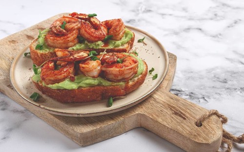 Sandwiches with avocado and caramelized shrimp, micro-greens, breakfast, on a plate, top view,