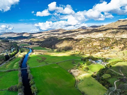 Farms and Mountains over River Dochart and Road A85 from a drone, Perthshire, Scotland, UK