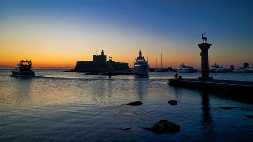 Harbour view at sunset with boats and a fortress, calm sea and evening atmosphere, sunrise, dawn,