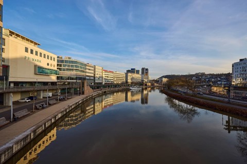 River Saar, modern architecture, trees, reflections on the water surface, fashion shop, Primark,