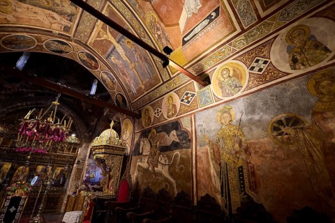 Church interior with frescoes and icons, richly decorated murals with biblical scenes, Thari