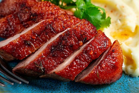 Roast duck breast, sliced with mashed potatoes, on a plate, close-up, no people