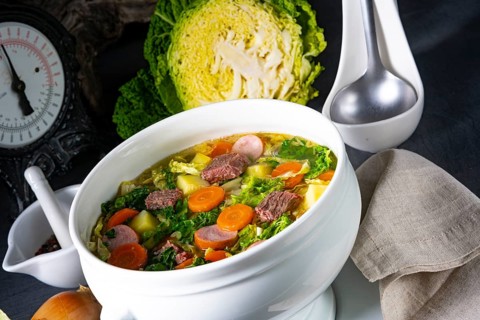Delicious savoy cabbage soup in a white vase