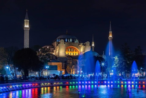 A picture of the Hagia Sophia and the colorful Sultan Ahmet Park Fountain at night