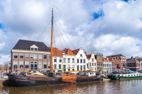 ZWOLLE, NETHERLANDS, MARCH 14, 2021: Old boats and barges in front of some nice gabled houses in