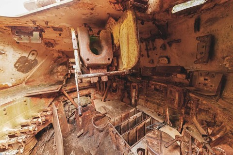 Dilapidated interior of a tank with rusty metal, full of old, rotting parts and structures, M41