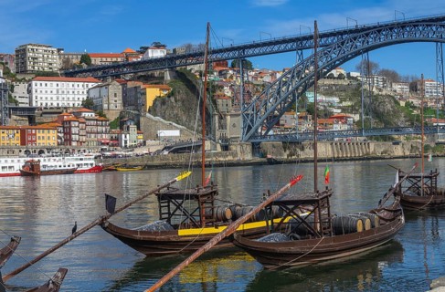 Traditional boats on Douro river with bridge in Porto, Portugal, Europe