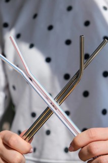 Woman holding Reusable Metal and plastic drinking Straws. Female Hand on reusable collapsible