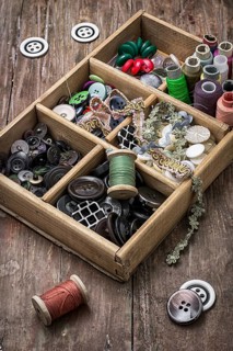 Old wooden box with thread and buttons for needlework in vintage style