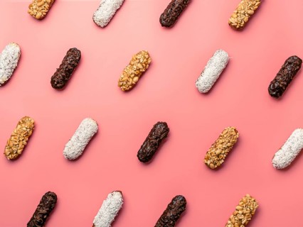 Pattern of different homemade eclairs on pink background. Top view of delicious healthy profitroles