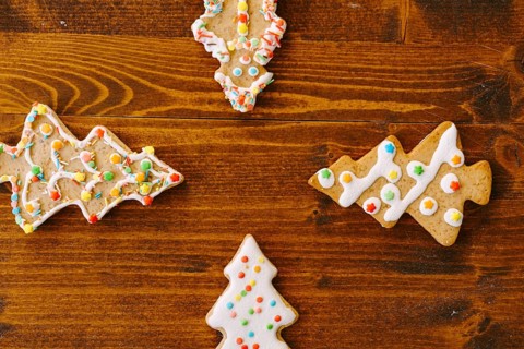 Four gingerbread cookies in the shape of Christmas trees. Arrows pointing to the center.