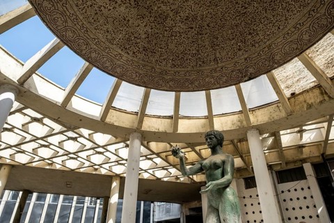 Sculpture Devojka under the ornate remains of a dome in Belgrade's dilapidated modern architecture