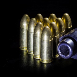 Black gun and bullets on a black background