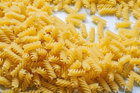 Stack of spiral macaroni on blue background food and drink concept
