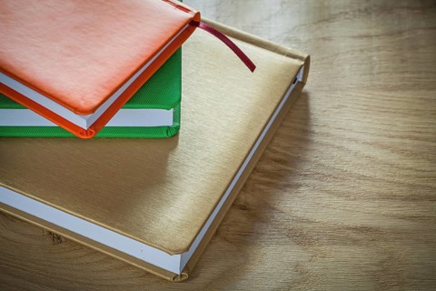Stack of office notebooks on wooden board