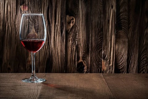 Copyspace view wineglass with red wine on vintage wooden background