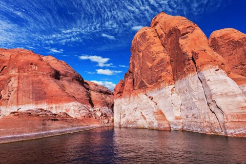 Lake Powell is surrounded by magnificent red hills. Walk on the boat at sunset. Scenic huge