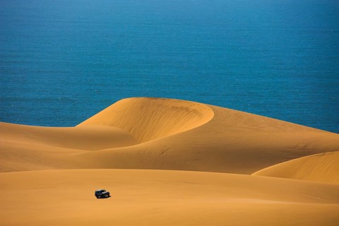Dangerous and gorgeous jeep - safari through the huge sand dunes on the ocean shore. Atlantic coast