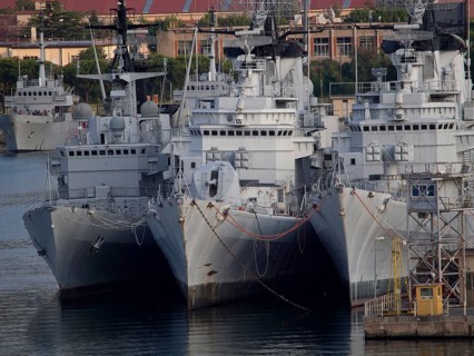 Three large military ships side by side in an industrial harbour area, la specia, Italy, Europe