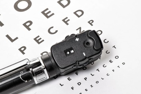 The ophthalmoscope is located on an eye test, with a white background