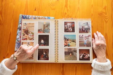 Top view of a senior caucasian woman looking at an old photo album themes of memories nostalgia