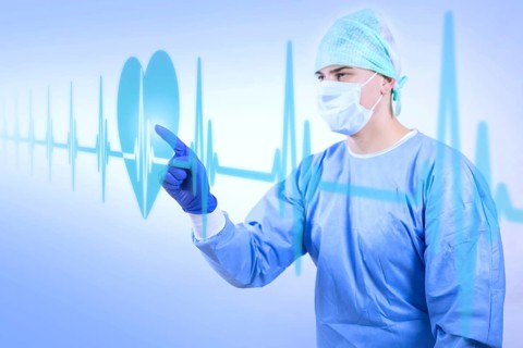 Surgeon doctor in sterile gloves preparing for operation in hospital looking at virtual hologram