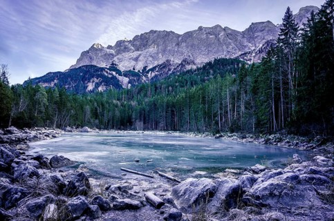 Winter scenery with an alpine frozen lake surrounded by the German Alps, near the municipality