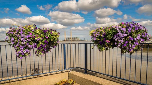 The shore of the River Thames in Gravesend, Kent, England, UK, with flower boxes and Tilbury Power