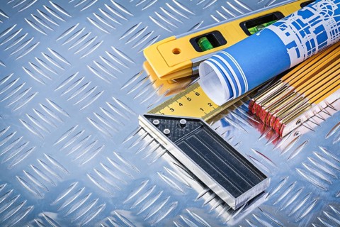 Construction level wooden meter blue rolled blueprints try square on grooved metal plate