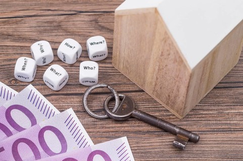 The photo shows a model house with various question cubes and a key
