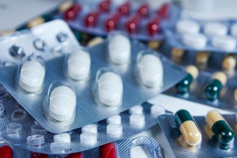 Close-up view of mixed blister packs containing white and colored capsules