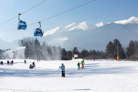 Bansko, Bulgaria, February 11, 2023: Bulgarian winter ski resort panorama with gondola lift cabins,