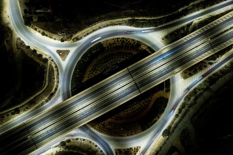 Aerial drone top view of a modern designed motorway junction. roundabout with cars moving. Cars