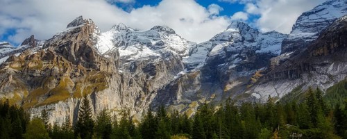 Swiss Alps banner mountain view of alpine as snow-capped mount peaks and pine trees background,