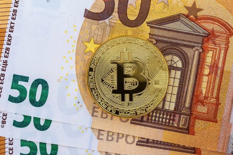 Bitcoin coin on euro banknotes as background