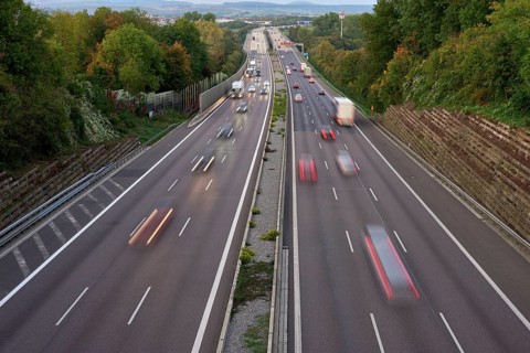 Night lights from car headlights on roundabout in night city. Traces of headlights on the road at